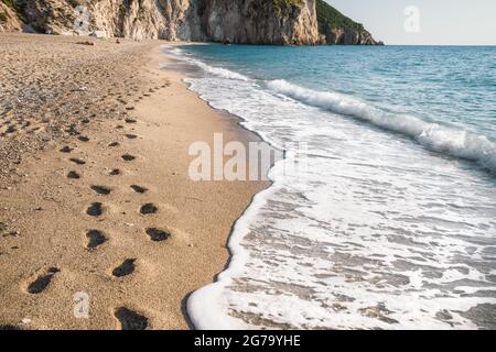 Fußschritte am Strand von Milos in der Nähe des Dorfes Agios Nikitas auf der ionischen Insel Lefkada, Griechenland. Stockfoto