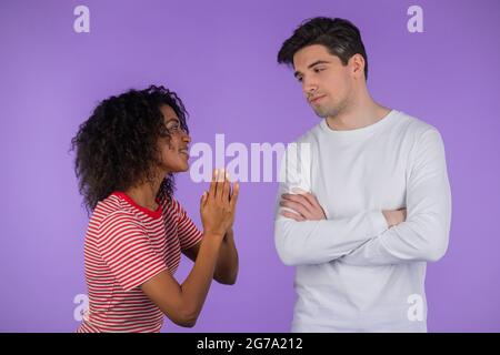 Nette afrikanische junge Frau bettelt ihren Freund oder Ehemann ber etwas  ber violettem Hintergrund. Mdchen wollen, dass ihr Mann Wnsche zu  befriedigen, helfen mit Stockfotografie - Alamy