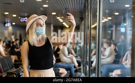 Coronavirus-Frau, die mit einer chirurgischen Maske läuft Gesichtsschutz, die in Menschenmengen am Bahnhof des Flughafens läuft Stockfoto