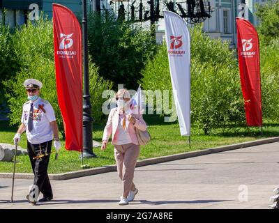 Omsk, Russland. 24. Juni 2020. Veteran des Großen Vaterländischen Krieges und seine Frau gehen zu einer festlichen Parade. Parade der militärischen Ausrüstung zu Ehren der t Stockfoto