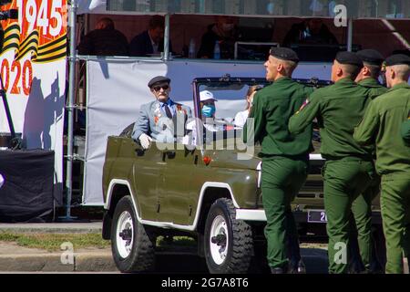 Omsk, Russland. 24. Juni 2020. Der Veteran des Großen Vaterländischen Krieges nimmt auf dem Militärwagen UAZ-469 die Paradekolonne der Fallschirmjäger ein. Parade der Mil Stockfoto