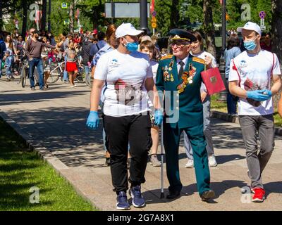 Omsk, Russland. 24. Juni 2020. Der Veteran spricht mit der jungen modernen Generation über den Krieg. Parade der militärischen Ausrüstung zu Ehren des Siegestages. Stockfoto