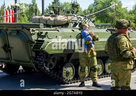 Omsk, Russland. 24. Juni 2020. Fallschirmjäger und Tanker werden mit Kindern vor Militärfahrzeugen BMP-2 fotografiert. Parade der militärischen Ausrüstung Stockfoto