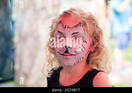 Kleine schöne blonde Mädchen mit Kitty Gesicht Malerei Stockfoto