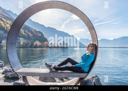 Blonde Frau sitzt im Freien in einem See und entspannt in der Natur. Stockfoto