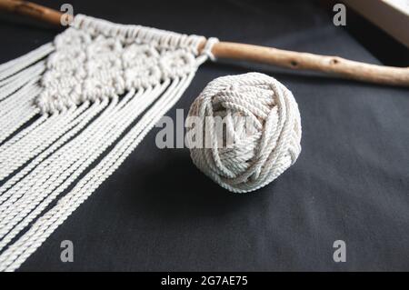 Dekorative handgemachte stilvolle Baumwolle Macrame Dekoration, Hobby-Interieur zum Aufhängen auf schwarzem Hintergrund. DIY Boho Haus Inneneinrichtung, Wand hängenden Deko Stockfoto