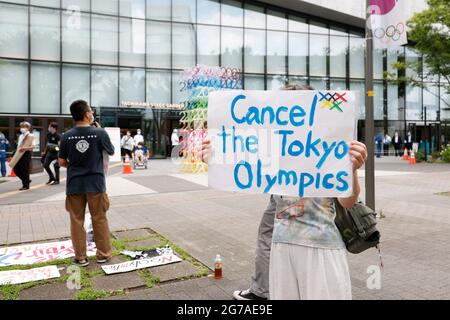 Tokio, Japan. Juli 2021. Ein antiolympischer Aktivist hält während eines Protestes vor dem Tachikawa Stage Garden ein Plakat. Die Fackellauf-Veranstaltungen begannen am 9. Juli in Tokio, weniger als einen Monat vor der Eröffnung der Olympischen Spiele. Quelle: Rodrigo Reyes Marin/ZUMA Wire/Alamy Live News Stockfoto