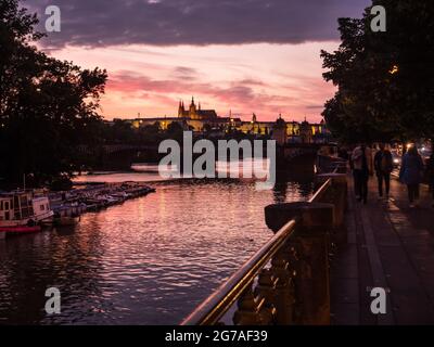 Fluss Moldau in Prag bei Sonnenuntergang mit St. Veits Kathedrale und romantischer Abenddämmerung Stockfoto