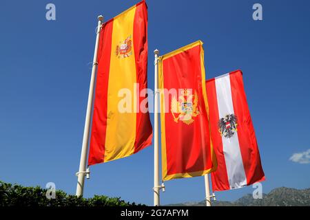 Flaggen mit den Wappen Montenegros, Österreichs und Spaniens fliegen über die Bucht von Kotor. Alte Stadt Perast, Montenegro Stockfoto