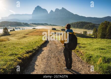 Wanderer auf der Straße bewundern den Sonnenaufgang auf der Seiser Alm, den Dolomiten, Italien Stockfoto
