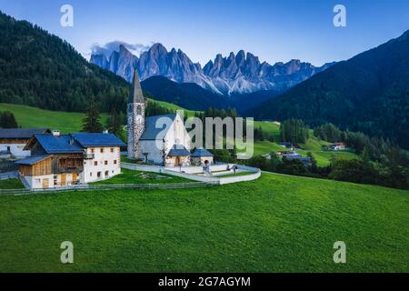 St. Magdalena Kirche im Val di Funes Tal in Abenddämmerung Licht, Dolomiten, Italien. Furchetta und Sass Rigais Berggipfel im Hintergrund Stockfoto