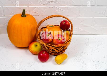 Nahaufnahme Herbst Ernte Hintergrund. Stillleben mit reifen Kürbis, Äpfeln, Birnen und Herbstblättern auf weißem Grund. Stockfoto