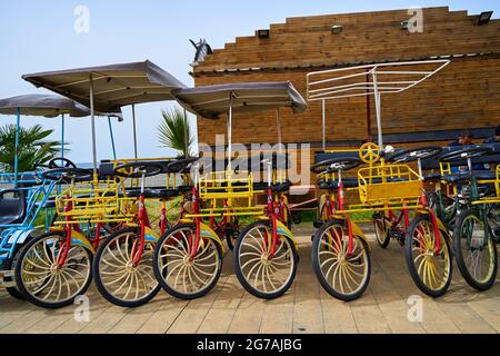 Fahrradverleih zum Radfahren entlang der Böschung. Fahrradparkplatz für die ganze Familie. Stockfoto