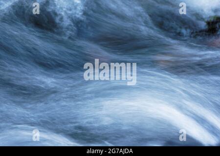 Unruhigen Wasser mit einem Kopf aus Schaum und Meeresspray in weiß, hellblau, dunkelblau und schwarz sanft fließenden. Stockfoto