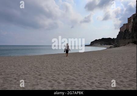 Tropea - Turista sulla spiaggia dell'Isola Bella al mattino presto Stockfoto