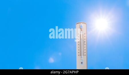 Thermometer bei heißen Temperaturen vor dem Hintergrund Stockfoto