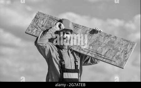 Provisorische Ausrüstung oder Strukturen montieren. Renovierungsservice. Mann trägt Faserplatten. Holzwerkstoff. Faserplatten in Wohn- und Stockfoto