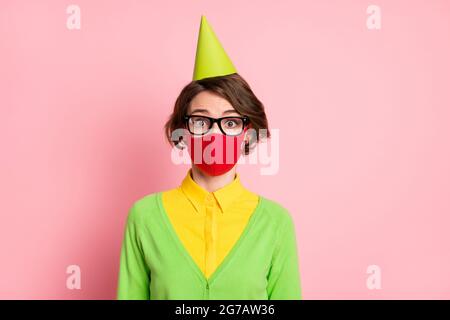 Foto von attraktiven erstaunt junge Frau tragen Schutzmaske Kegel Hut isoliert auf rosa Hintergrund Stockfoto