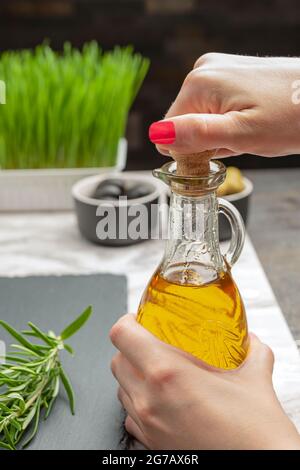 Olivenöl. Eine Frau gießt Olivenöl in eine Untertasse. Stockfoto