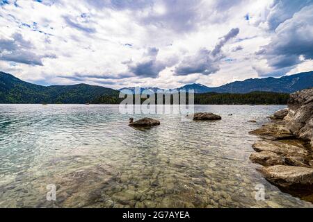 Blick über das Wasser des Eibsee mit bewölktem Himmel, Grainau, Oberbayern, Deutschland Stockfoto