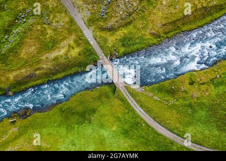 Die Luftaufnahme eines milchig blauen Flusses und einer Brücke, Island. Stockfoto