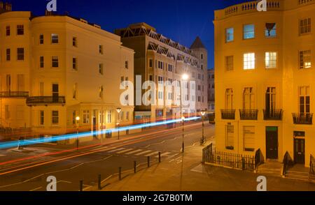 Kreuzung des unteren Teils des Brunswick Place am oberen Ende des Brunswick Square und der Western Road, Hove. Morgendämmerung. Regency-Gehäuse, beleuchtet von Straßenlaternen. Leichte trais vom vorbeifahrenden Straßenfahrzeug. Brighton & Hove, East Sussex, England, Großbritannien Stockfoto