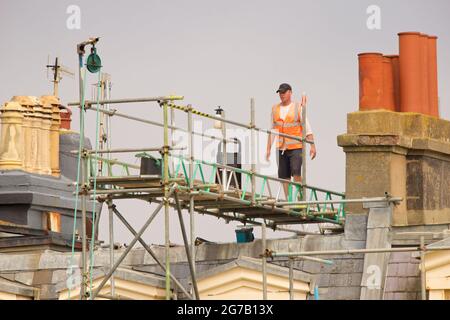 Gerüste auf dem Dach mit einem Arbeiter, Brunswick Square Hove East Sussex England Gerüste für die fünfjährige Neulackierung. Stockfoto