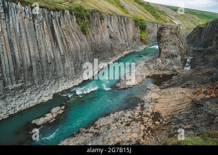 Studlagil Basalt Canyon, mit seltenen vulkanischen Basalt-Säulen-Formationen und blauem Fluss aus Gletscherschmelzwasser. Island. Stockfoto