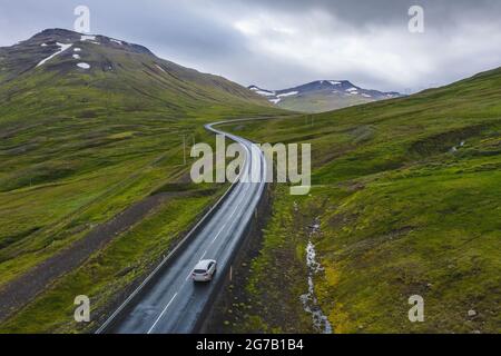 Einsame Mietwagen-Fahrt auf abgelegener Straße mit wunderschöner Landschaft von Island. Stockfoto