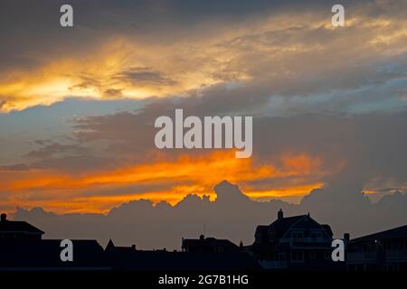 Farbenfroher Sonnenuntergang in einem Himmel, der von Cumulo-Nimbus-Wolken gesäumt ist, von Avon-by-the-Sea, New Jersey, USA -03 aus gesehen Stockfoto
