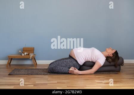 Schwanger Frau praktiziert Yoga in suptha virasana Übung Stockfoto