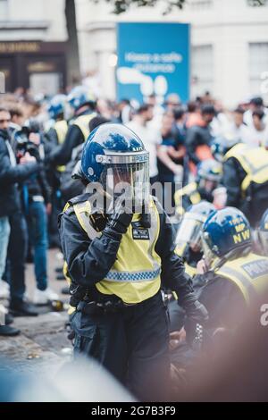 London | UK - 2021.07.12: Polizeibeamte verhaften zwei aggressive Männer auf dem trafalgar Square kurz vor dem EM 2020-Fußballspiel Stockfoto