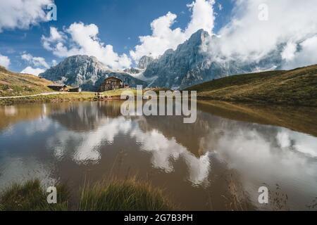 Baita Segantini Berg mit Cimon della Pala Gipfel, Zuflucht im alpinen See reflektiert. Rolle Pass, Provinz Trentino, Italien, Europa Stockfoto