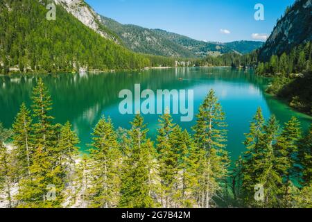 Luftaufnahme auf dem Pragser Wildsee, einem See in den Südtiroler Dolomiten. Hohe Gebirgsketten um den See herum. Der Himmel und die Berge spiegeln sich im See. Stockfoto