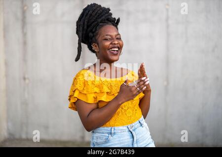 Glückliche junge Frau mit Dreadlocks im Freien Stockfoto