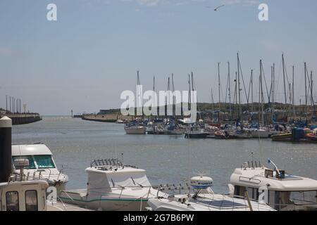 Boote gesehen, die entlang des Flusses Arun mit Blick auf die Flussmündung zum Meer vertäut sind. Stockfoto