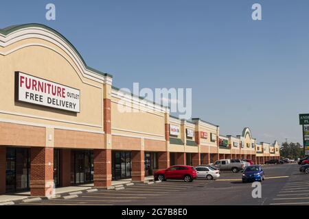 Augusta, GA USA - 04 21 21: Close up Vintage Retro Stuck Retail Shopping Strip Mall and parked cars side view - Bobby Jones Expressway Stockfoto