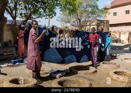 Männer präsentieren Indigo-Kleidung an den Färbegruben in Kano, Bundesstaat Kano, Nigeria Stockfoto