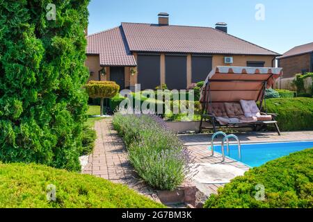 Villa im europäischen Stil mit Pool und Garten mit schön getrimmten Büschen Stockfoto