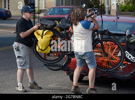 Zwei Radfahrer entladen ihre Elektrofahrräder, während sie sich auf die Erkundung von Santa Fe, New Mexico, vorbereiten. Stockfoto