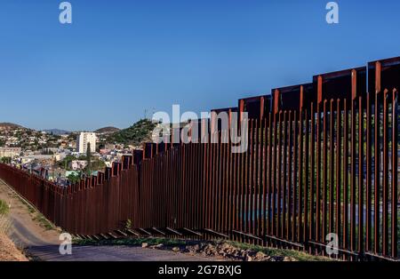 US-Grenzzaun, „Pollerbau“, der als Fußgängersperre dient, von der US-Seite aus in Nogales Arizona USA mit Nogales Sonora Mexico o betrachtet Stockfoto