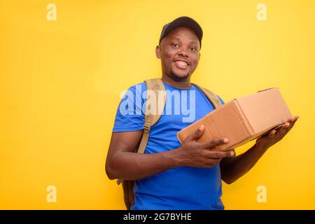 Ein afrikanischer Liefer- oder Versandmann mit einem Rucksack, Tragekisten und einer Gesichtskappe Stockfoto