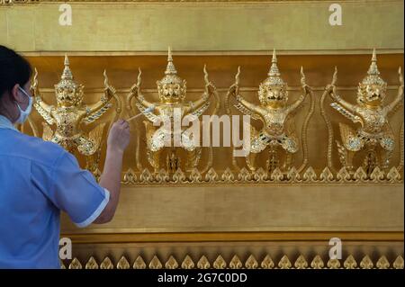 25.01.2017, Bangkok, Thailand, Asien - EINE Putzfrau reinigt vergoldete buddhistische Figuren im Wartebereich am internationalen Flughafen Suvarnabhumi. Stockfoto