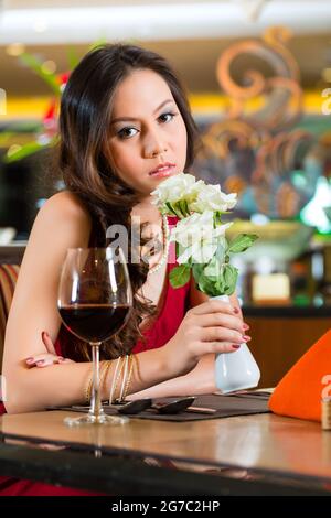 Chinesische bekam nervös, in der Hoffnung, einsam, verträumt, betrübte Frau in einem Restaurant wartet auf ein Datum Stand auf Stockfoto
