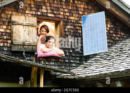 Junges Paar im Bett auf dem Boden einer Scheune oder einer Berghütte in den Alpen genießt die Freizeit Stockfoto