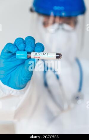 Ärztin oder Krankenschwester im Schutzanzug mit positivem blo Stockfoto