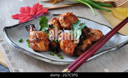 Koreanische Barbecue-Hähnchen-Drumsticks auf Schale mit Essstäbchen in Bannergröße Bild Stockfoto