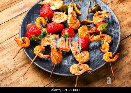 Appetitlich gegrillte Garnelen auf Holzspießen mit Erdbeeren.Garnelen bbq Stockfoto