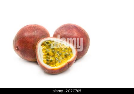 Passionsfrucht in der Gruppenanzeige wird eine aufgeschnittene Passionsfrucht mit zwei ganzen Früchten zusammengestellt, Bild ein weißer Hintergrund, Nahaufnahme, um Details zu sehen. Stockfoto