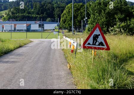 aadorf, schweiz 17. juni 2021: Baustellenschild neben Durchgangsstraße und grüne Wiesenwarnleuchten an der Schranke Stockfoto